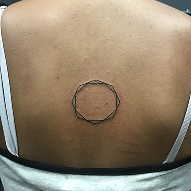 circle symbol tattoo on back