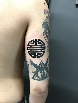 circle symbol tattoo on bicep