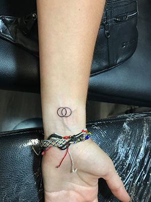 circle symbol tattoo on wrist