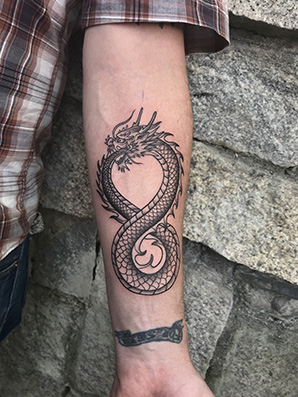 blackwork dragon tattoo on forearm