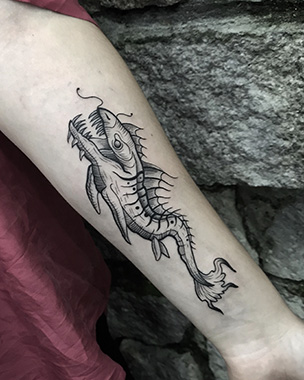 blackwork fish tattoo on forearm