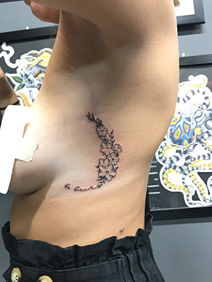 flower blackwork tattoo on rib