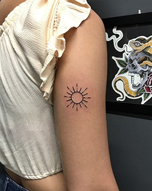 sun outline tattoo on tricep